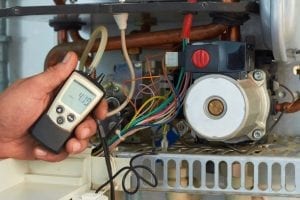 Boiler repair being carried out by a plumber